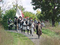 Re-enactors led by Dave Bernier, of Southampton, MA portraying American General Horatio Gates, bring Colors forward.