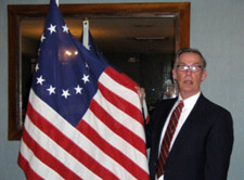 Charles W. King displays the Betsy Ross flag he bought for Chapter use - Photo by Duane Booth