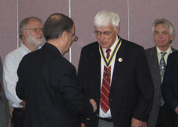 Past President Richard W. Sage congratulates dual chapter member President Duane Booth after presenting him with the Society's State President Medallion