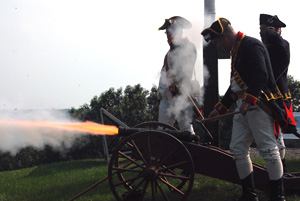 Saratoga Battle Chapter member Brett Trufant applies fire to a cannon built by Saratoga Battle Chapter Treasurer Mike Companion (a dual Walloomsac Battle Chapter member, behind smoke) at the 232nd anniversary of the Battle of Bennington held at the NYS Battle of Bennington Historic Site in North Hoosick, NY, on 8/16/2009. - Photo courtesy of Bob Wilson
