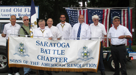 The author, Dennis Booth (green shirt), is recruited to carry the chapter's standard. (L-R) R. Harry Booth, Dennis Booth, SBC President Tom Dunne, WB President John H. Sheaff, SBC Past President Primitivo Africa, VT Society President Douglass 'Tim' Mabee, SBC Past President Duane Booth, Patrick Festa