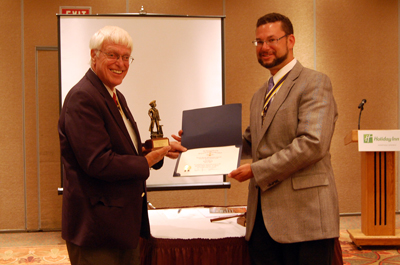President Africa presents Past President Duane Booth with the Duane Booth Minuteman award.  A photo of the certificate and the statue seen on the front page of the website in the 'Photo Highlight' area (lower right)- Photo: Joyce Armstrong